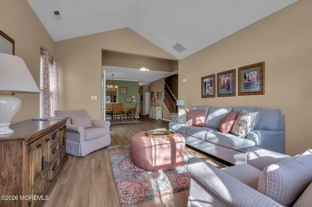 a open kitchen with stainless steel appliances granite countertop a stove top oven a refrigerator a sink and a dining table with garden view