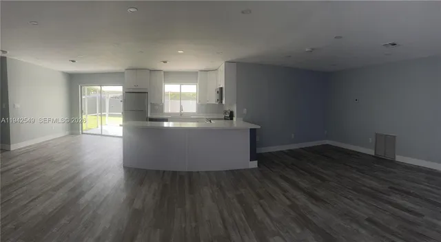 a kitchen with stainless steel appliances a refrigerator and wooden floor