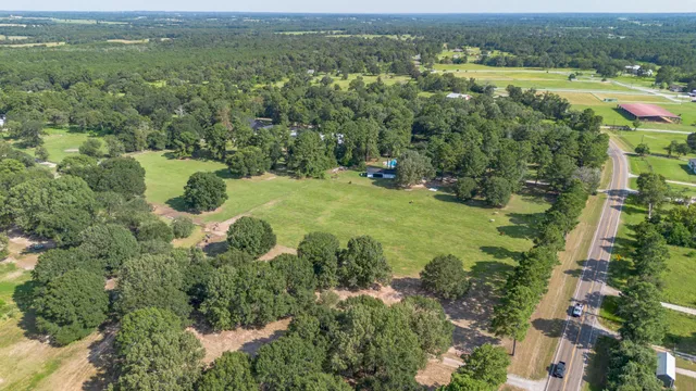 an aerial view of residential houses with outdoor space and trees