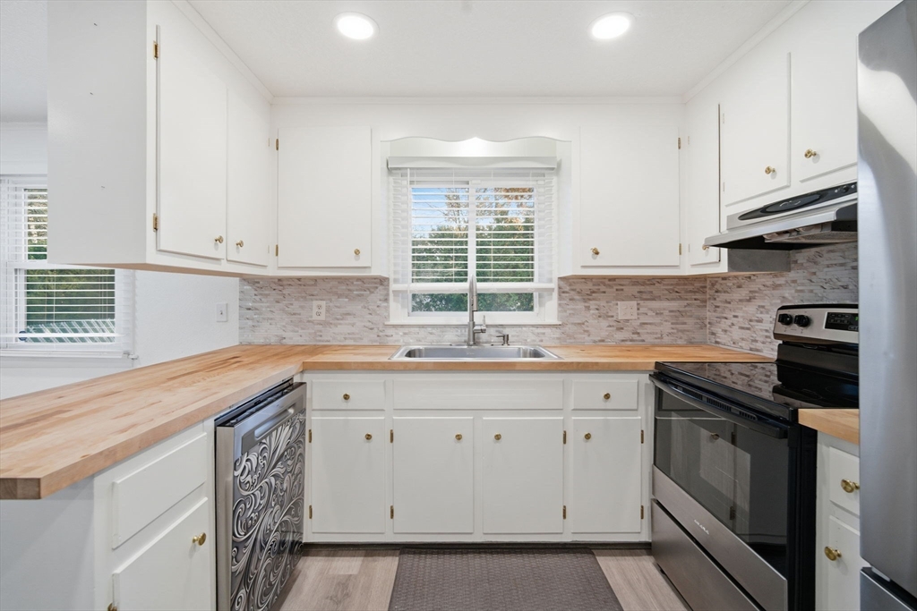 181 Beauchamp Terrace Chicopee, MA 01020 - Photo 6 of 36 a kitchen with white cabinets appliances a sink and a window