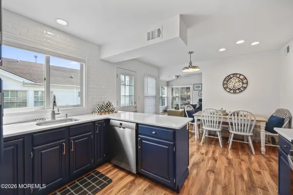 a kitchen with kitchen island granite countertop wooden floors and wooden cabinets