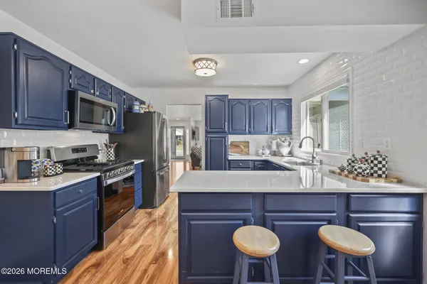 a kitchen with stainless steel appliances granite countertop a refrigerator stove and sink