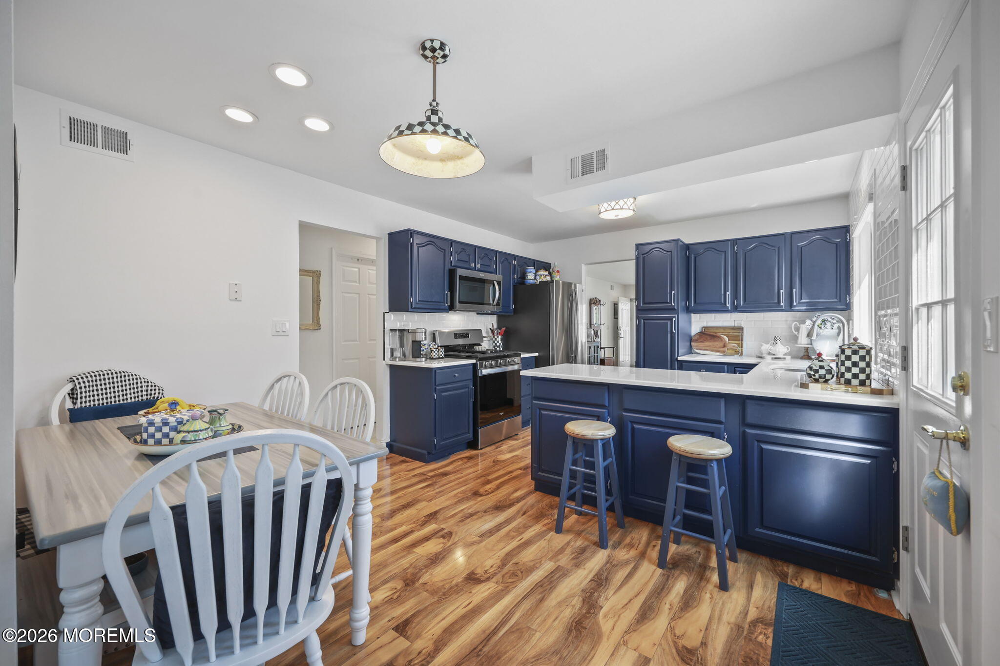 2254 Beltane Road Toms River, NJ 08755 - Photo 21 of 44 a kitchen with stainless steel appliances kitchen island granite countertop a refrigerator a stove a sink a dining table and chairs with wooden floor