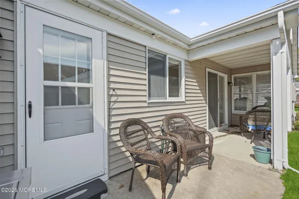 a view of a house with a yard and chairs
