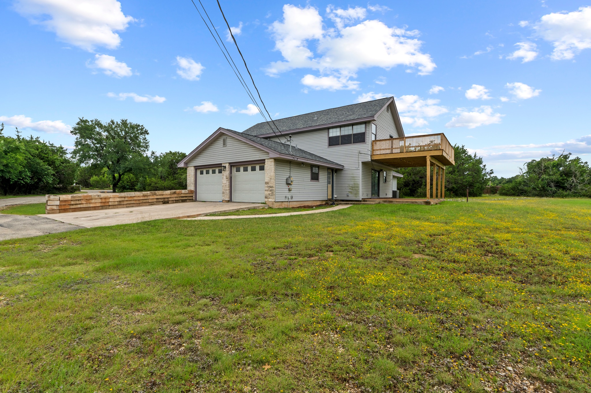 205 Sedro Trail Georgetown, TX 78633 - Photo 3 of 32 A spacious home with an attached garage and an elevated deck overlooks a verdant landscape.