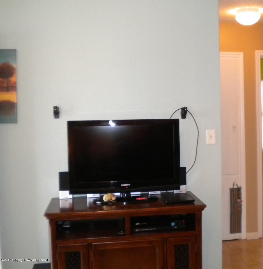 4224 South Harrison Street Amarillo, TX 79110 - Photo 5 of 15 a living room with flat screen tv and gym equipment