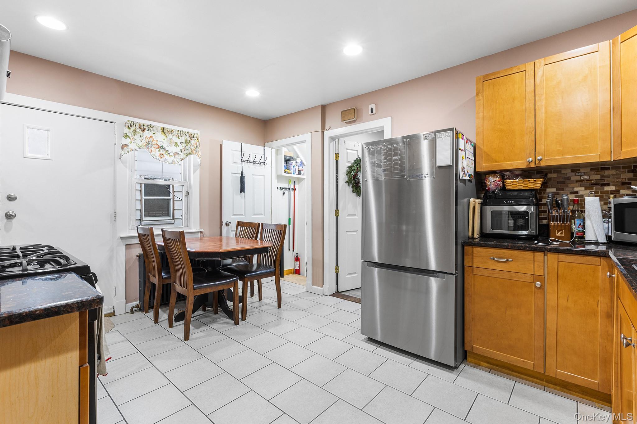 42 Warren Street New Rochelle, NY 10801 - Photo 4 of 14 a kitchen with stainless steel appliances granite countertop a refrigerator a stove a sink a dining table and chairs