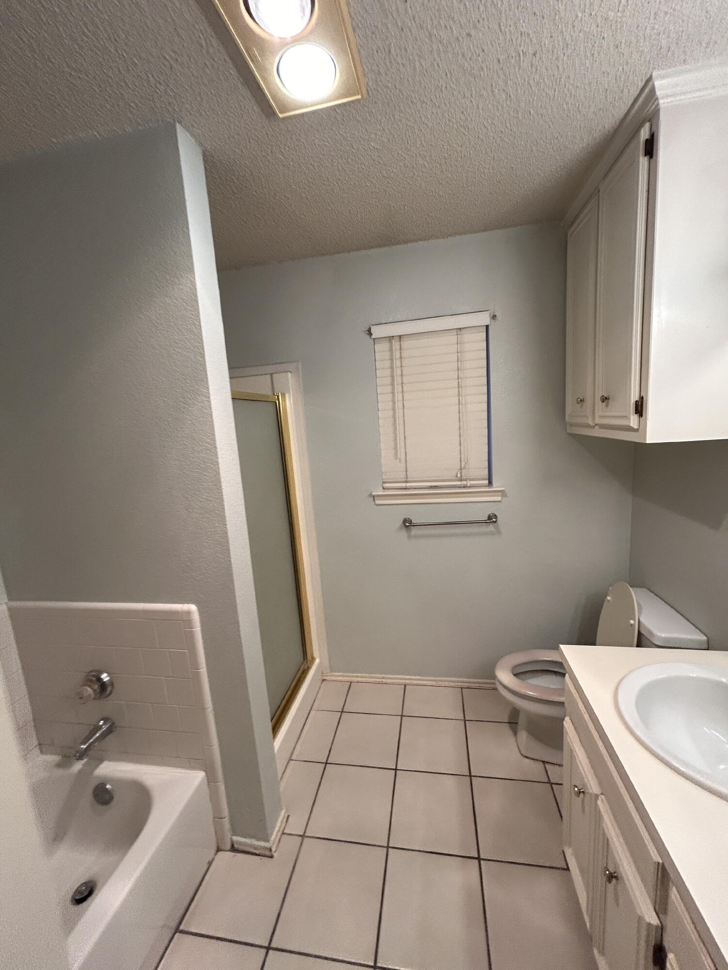 6220 7th Street Lubbock, TX 79416 - Photo 11 of 17 a bathroom with a sink a toilet and a mirror