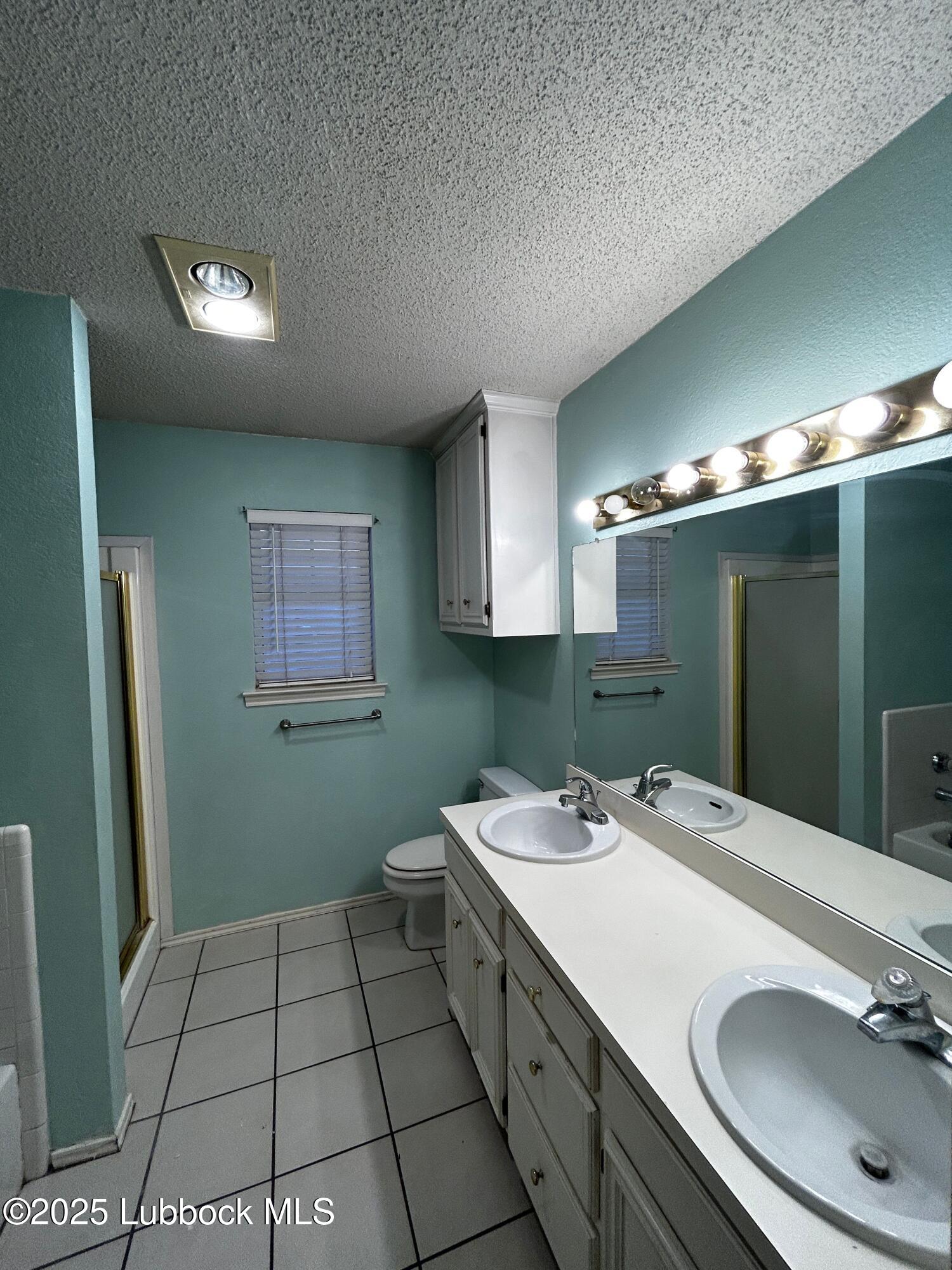 6220 7th Street Lubbock, TX 79416 - Photo 12 of 28 a bathroom with a sink toilet and mirror