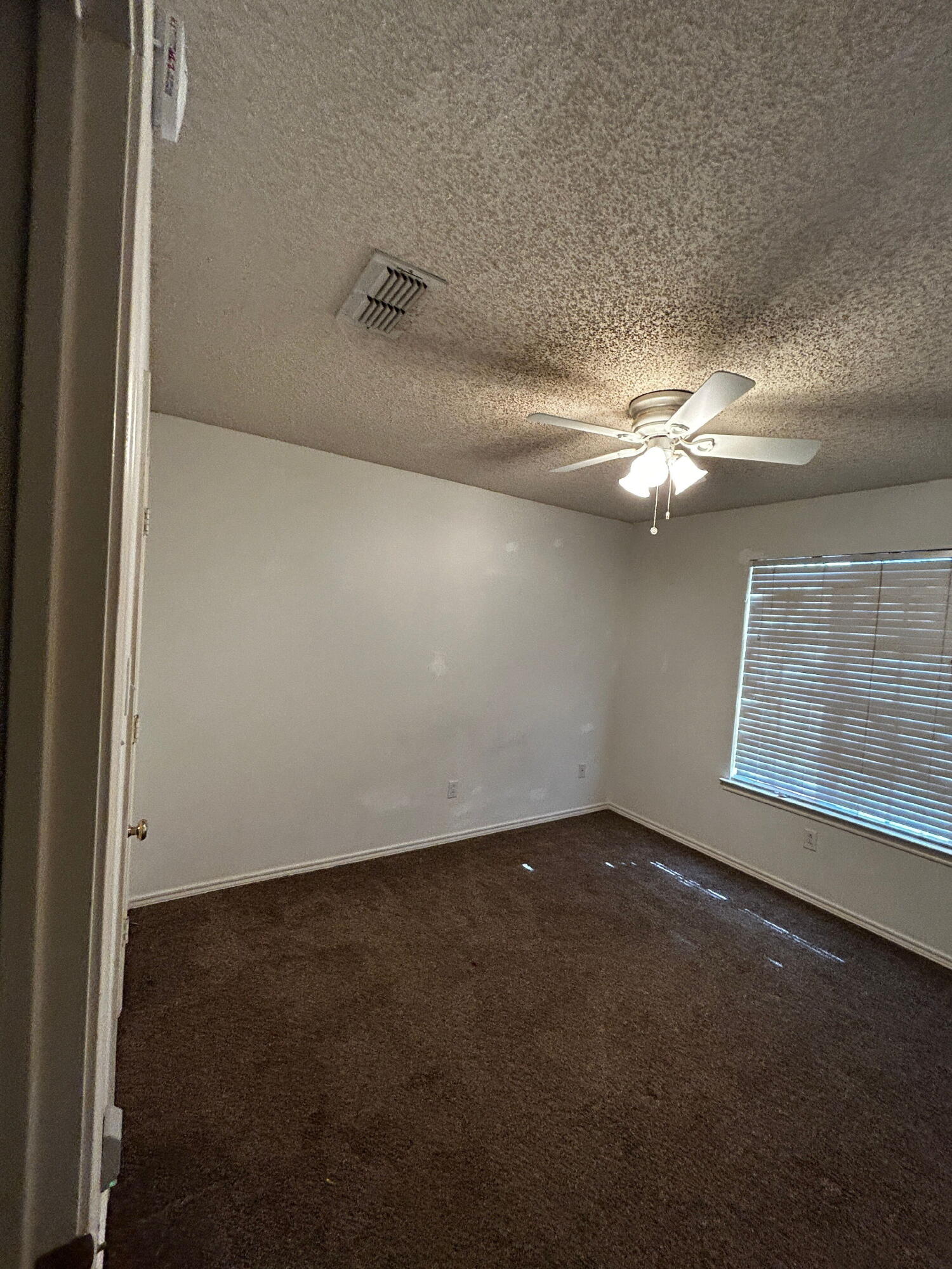 6220 7th Street Lubbock, TX 79416 - Photo 15 of 17 an empty room with windows and fan