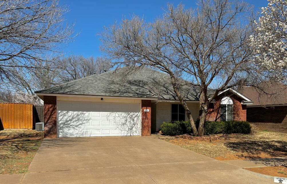6220 7th Street Lubbock, TX 79416 - Photo 17 of 28 a front view of a house with a yard and garage