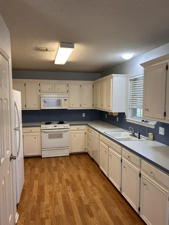 a large kitchen with stainless steel appliances lots of counter space and wooden floor
