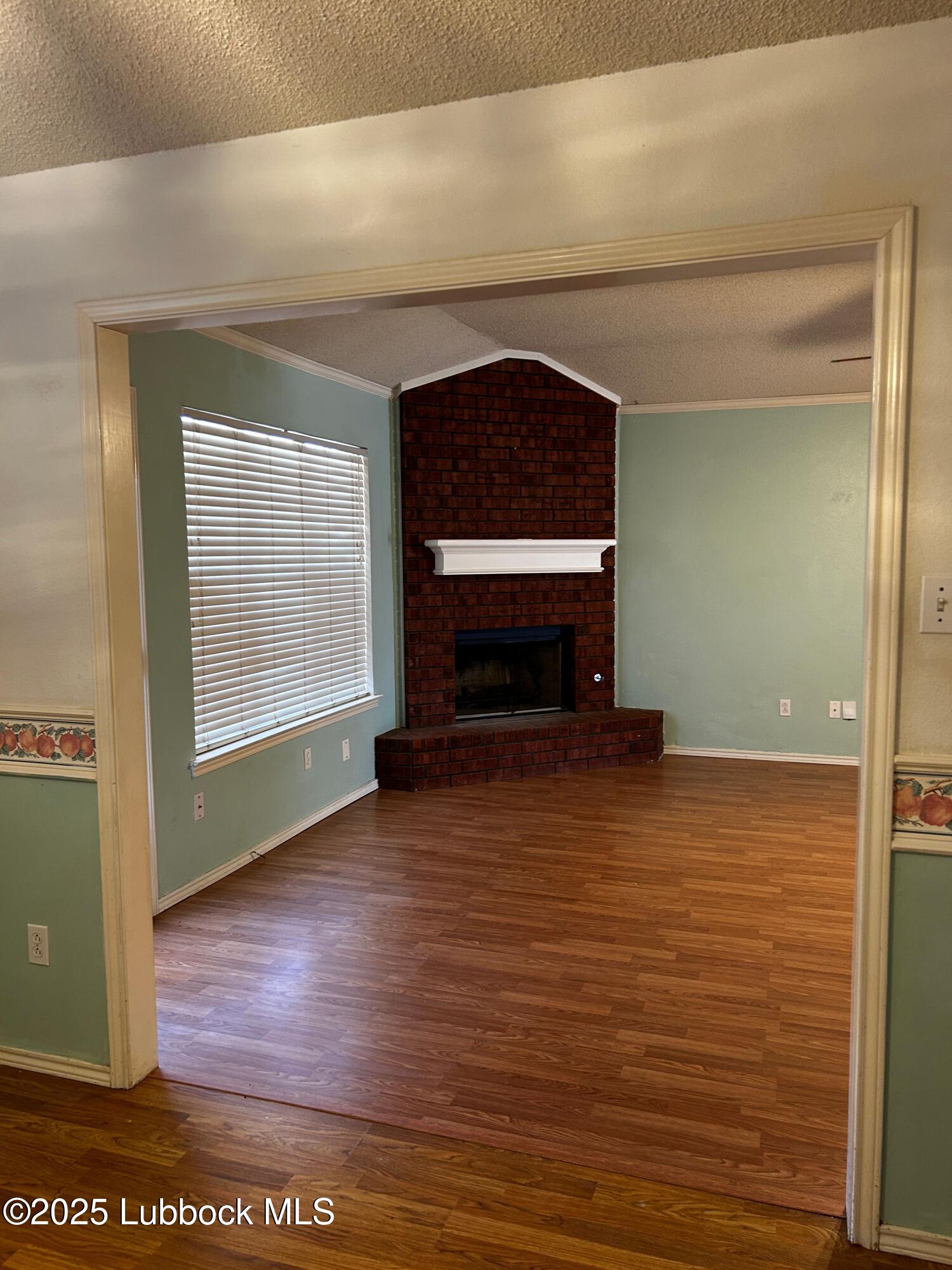 6220 7th Street Lubbock, TX 79416 - Photo 2 of 28 a view of empty room with window and fireplace