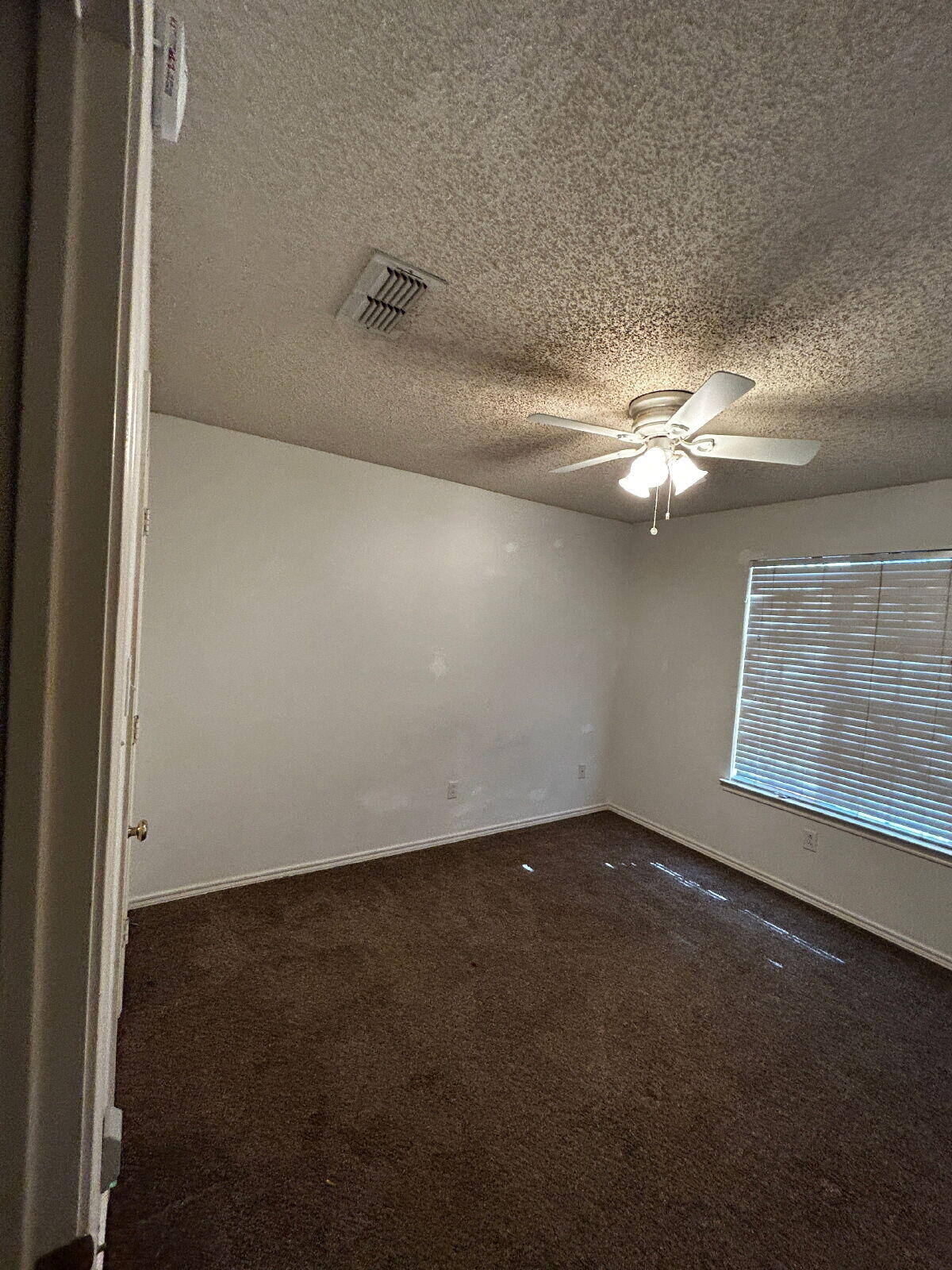 6220 7th Street Lubbock, TX 79416 - Photo 21 of 28 an empty room with windows and fan
