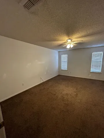 en empty room with windows and fireplace