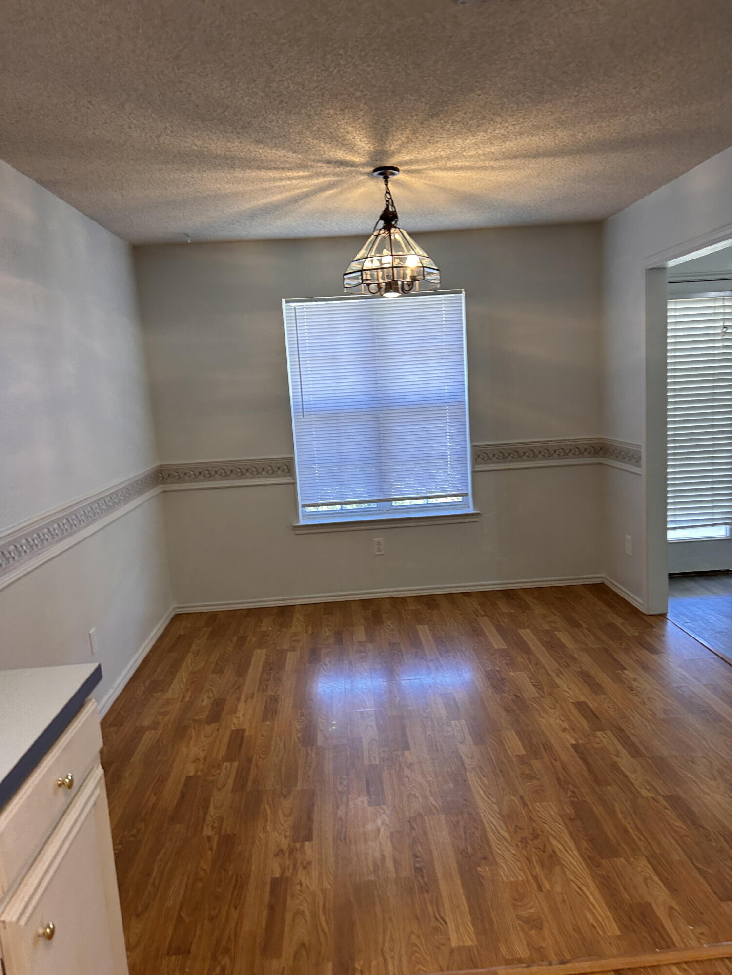 6220 7th Street Lubbock, TX 79416 - Photo 3 of 17 a view of empty room with wooden floor and fan