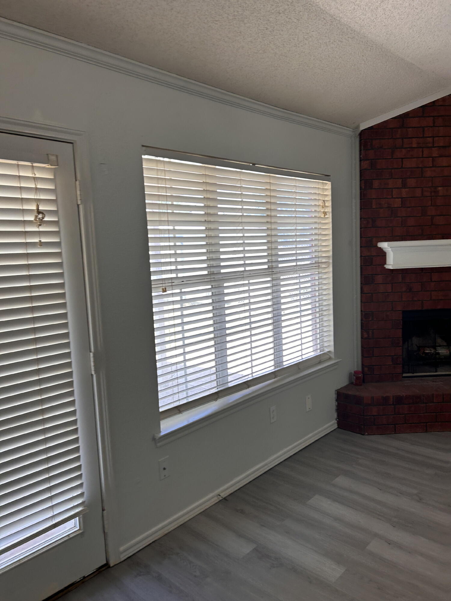 6220 7th Street Lubbock, TX 79416 - Photo 4 of 17 a view of an empty room with wooden floor and a window