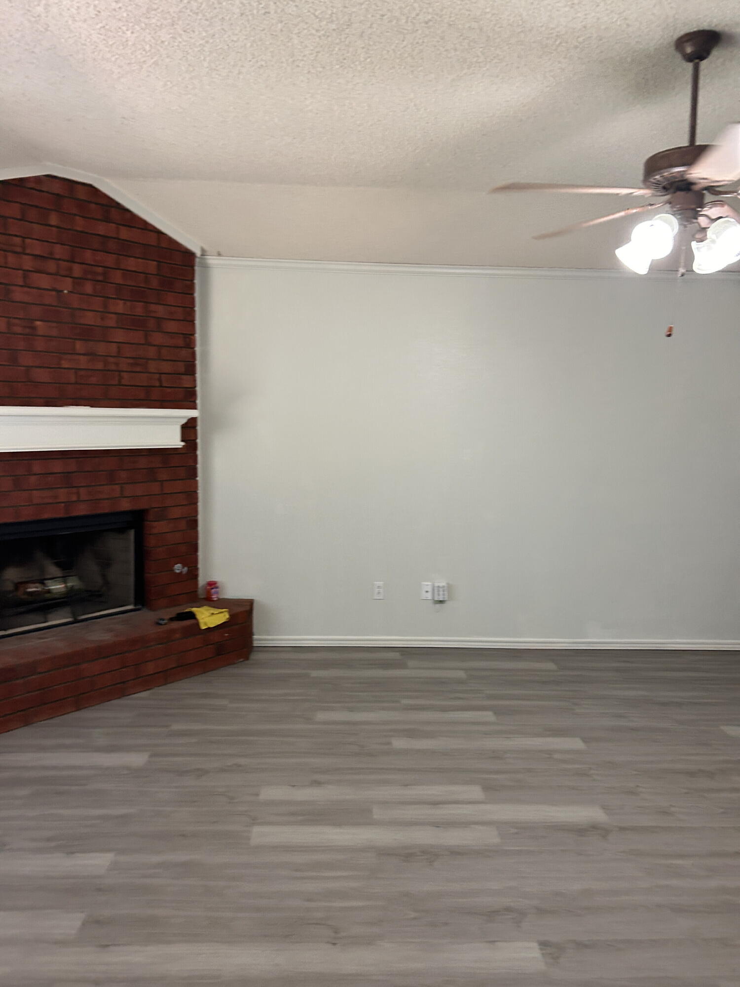 6220 7th Street Lubbock, TX 79416 - Photo 5 of 17 a view of empty room with wooden floor and fireplace