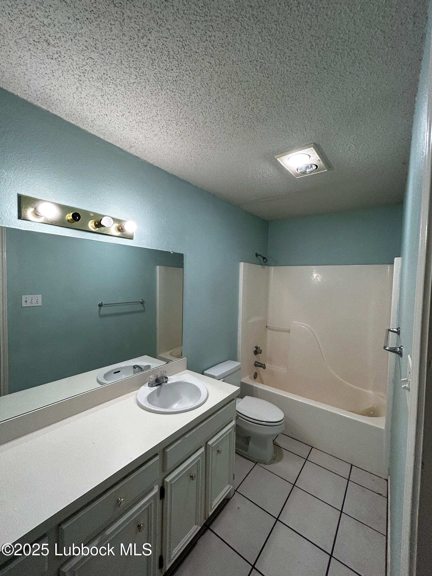 6220 7th Street Lubbock, TX 79416 - Photo 10 of 28 a bathroom with a sink a toilet and shower