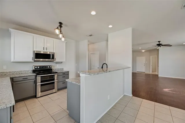 a kitchen with stainless steel appliances granite countertop a stove and a sink