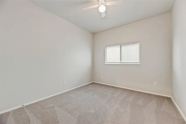 an empty room with a chandelier fan