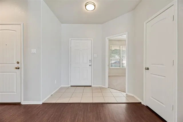 an empty room with wooden floor & windows
