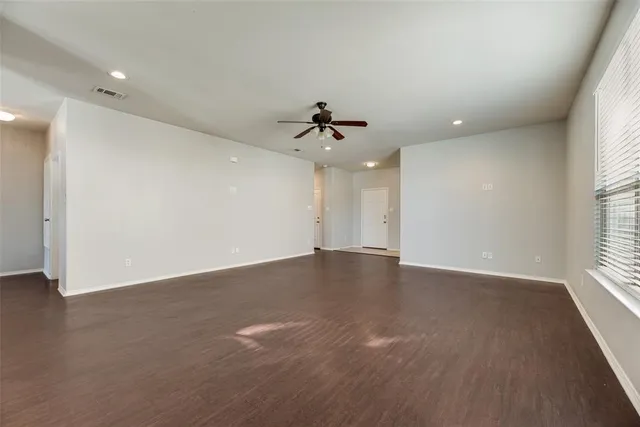 an empty room with a window and a ceiling fan