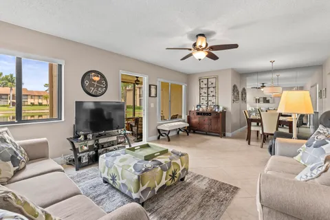 a living room with furniture a clock on wall and a flat screen tv