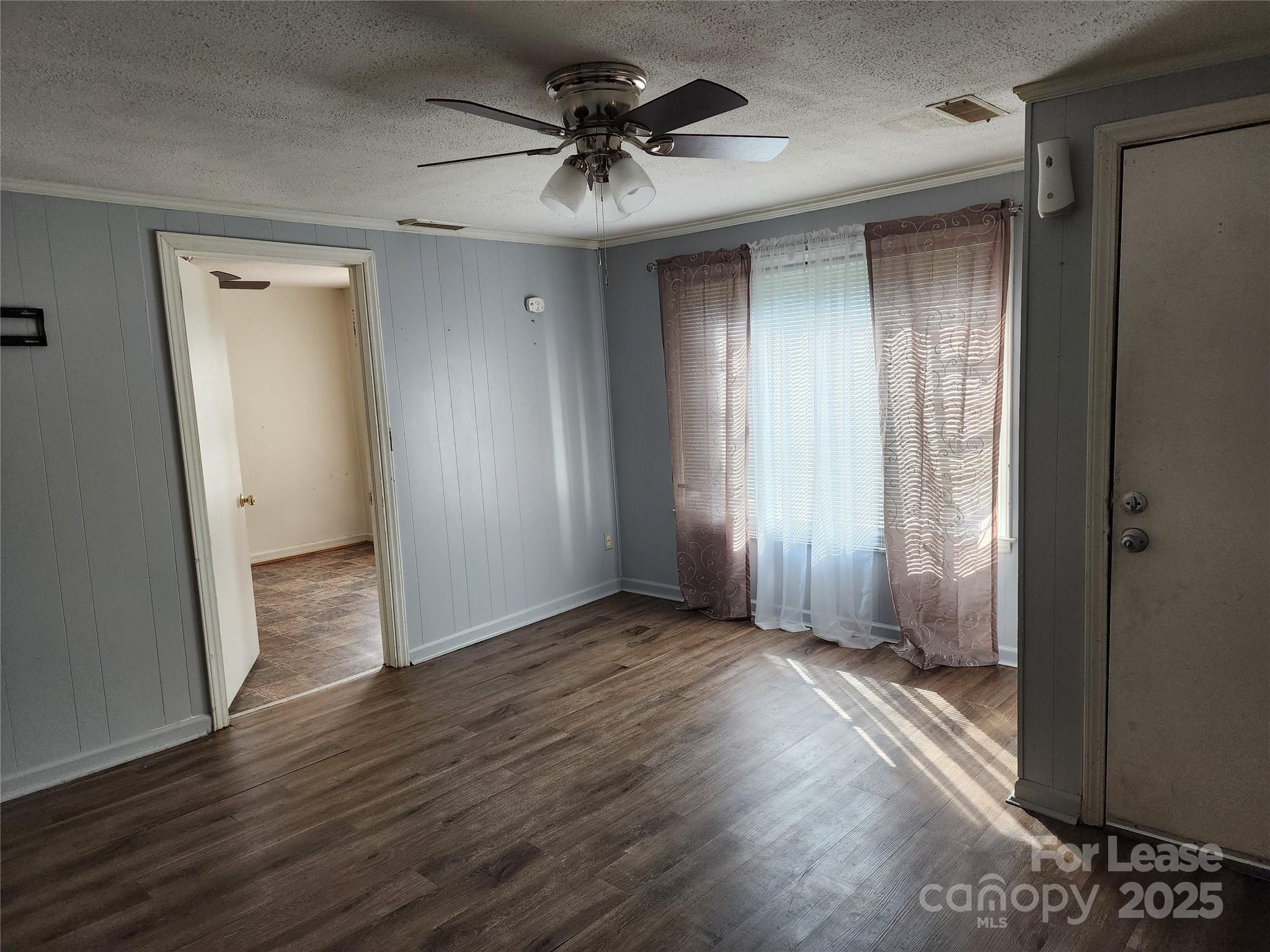 435 Rankin Street Northwest Lenoir, NC 28645 - Photo 6 of 10 an empty room with wooden floor and a ceiling fan