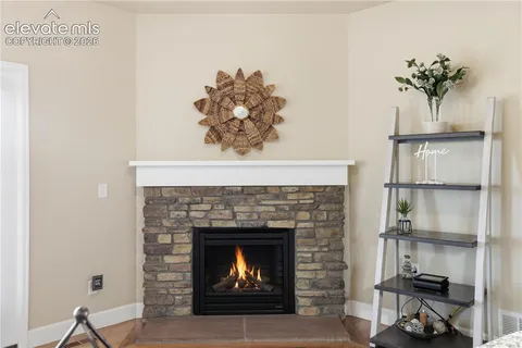a living room with a fireplace and wooden floor