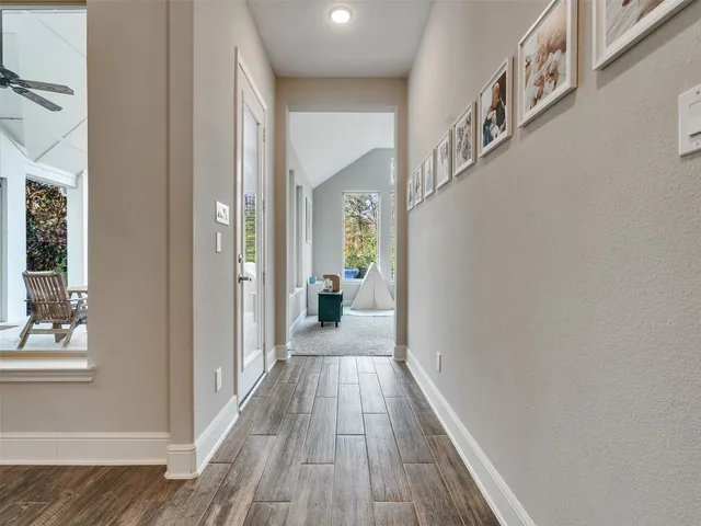 a view of a hallway with wooden floor and staircase