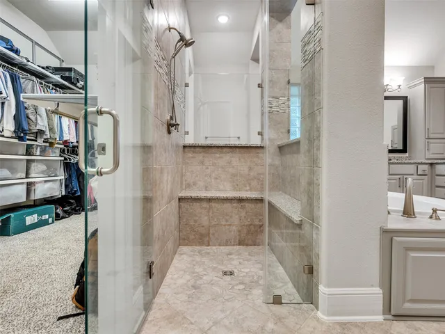 a bathroom with a granite countertop shower a mirror and a sink