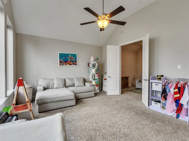 a living room with furniture and ceiling fan