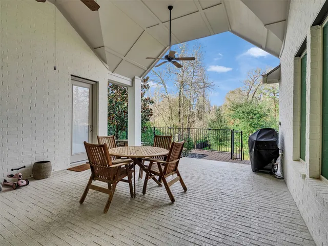 a view of a roof deck with table and chairs floor to ceiling window with wooden floor