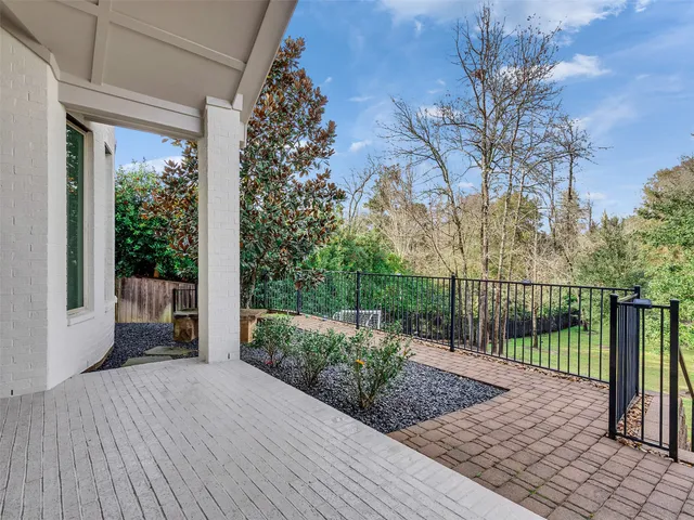 a view of a deck with a large window and wooden fence
