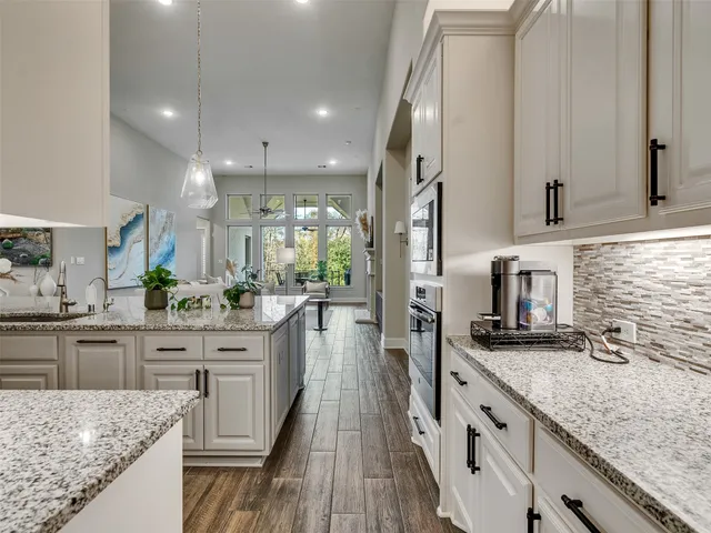 a kitchen with granite countertop a sink stove cabinets and refrigerator