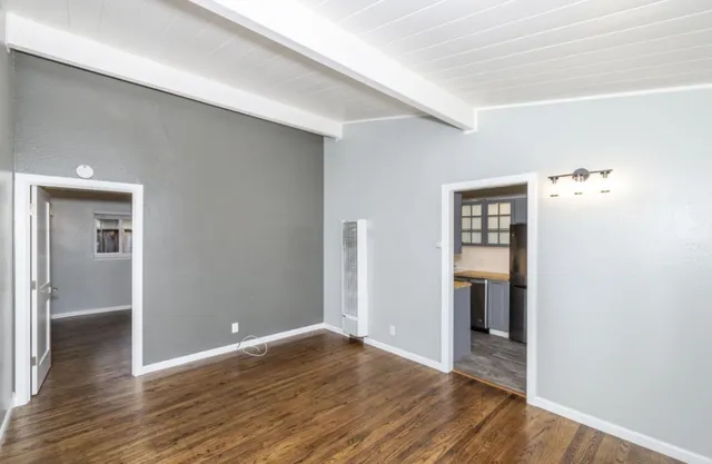 a kitchen with stainless steel appliances granite countertop a refrigerator a sink dishwasher a stove and white countertops with wooden floor