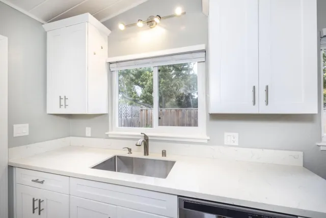 a kitchen with stainless steel appliances white cabinets and a stove top oven