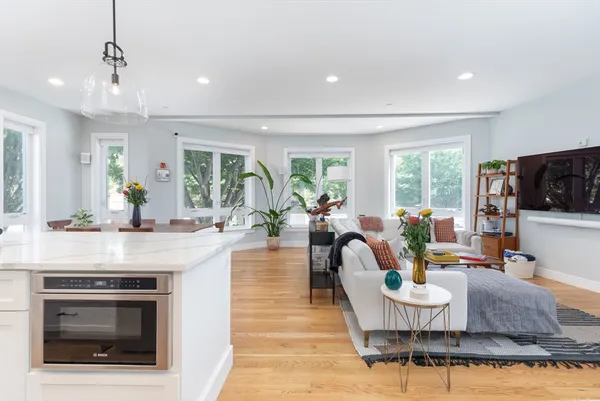 a living room with fireplace furniture and a large window