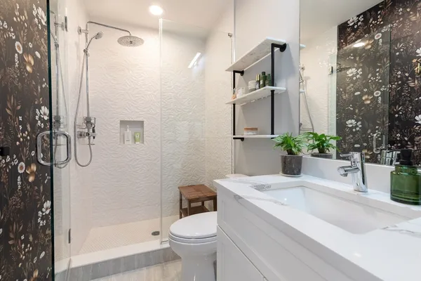 a bathroom with a sink a toilet and shower