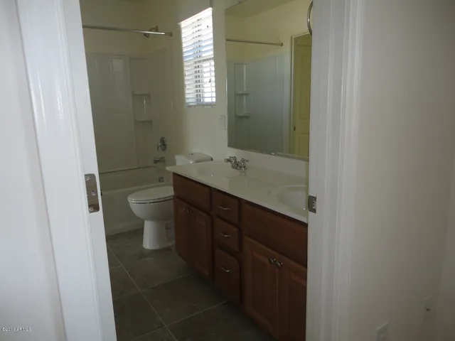 a bathroom with a granite countertop sink a toilet and a mirror