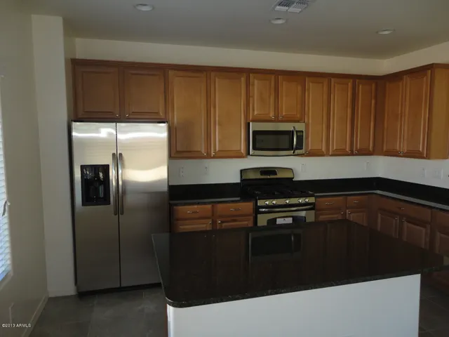 a kitchen with granite countertop wooden cabinets and stainless steel appliances