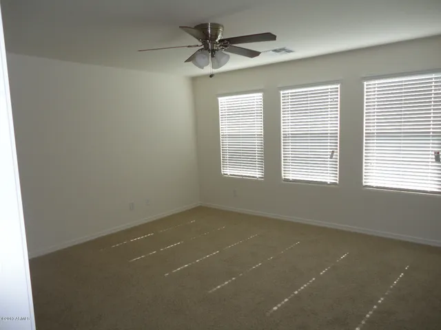 an empty room with a window and a ceiling fan