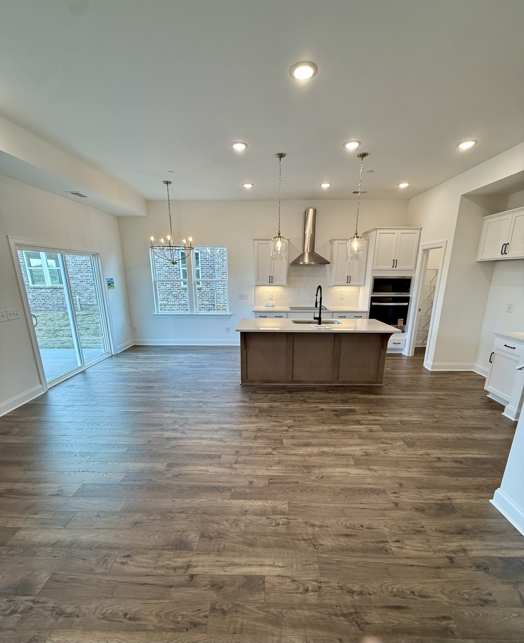 6421 Waymeet Dr Spring Hill Spring Hill, TN 37174 - Photo 4 of 29 a view of kitchen with kitchen island a sink wooden floor and a living room view