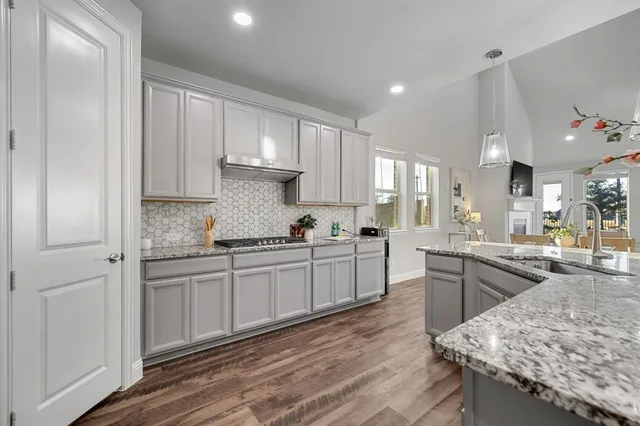 a kitchen with stainless steel appliances granite countertop a sink stove and refrigerator