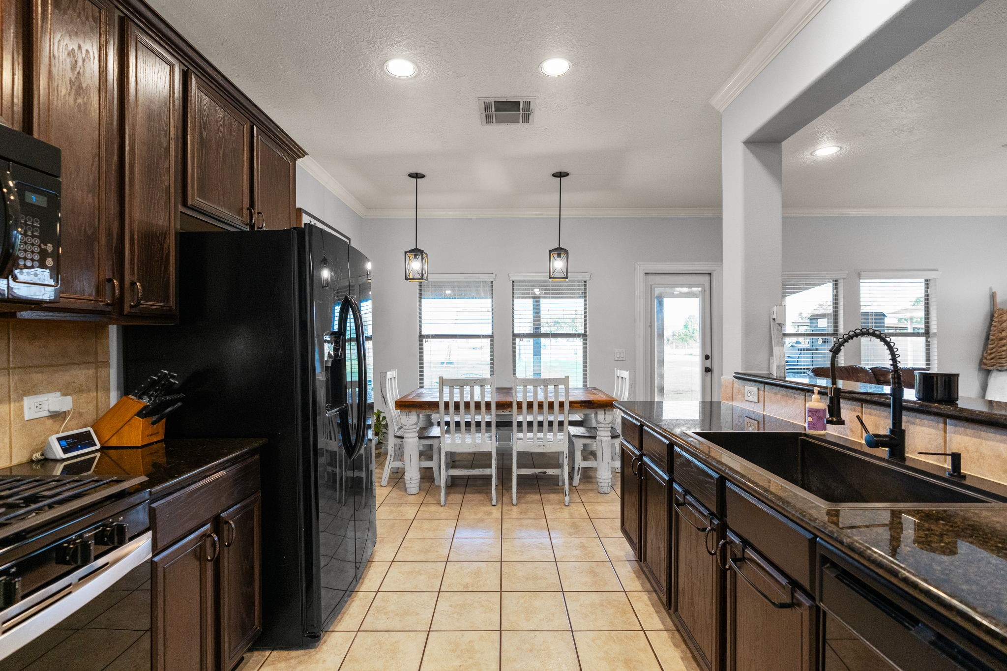 5942 Wildflower Road Sealy, TX 77474 - Photo 9 of 41 a kitchen with granite countertop a stove a sink dishwasher a refrigerator and cabinets with wooden floor