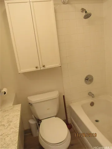 a white toilet sitting next to a bath tub