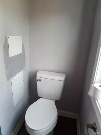 a white toilet sitting next to a window