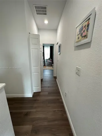 a view of a hallway with wooden floor