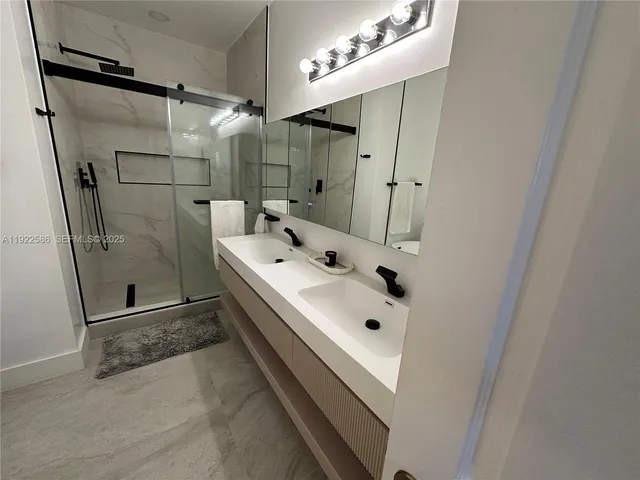 a bathroom with a tub sink a mirror and shower